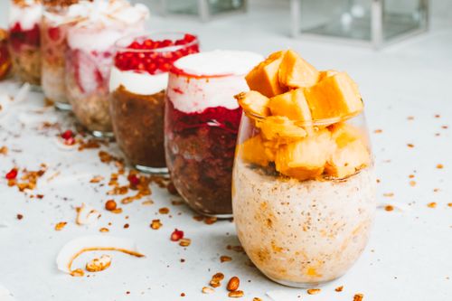 Free Assorted healthy fruit parfaits with toppings, beautifully displayed, ideal for food photography. Stock Photo