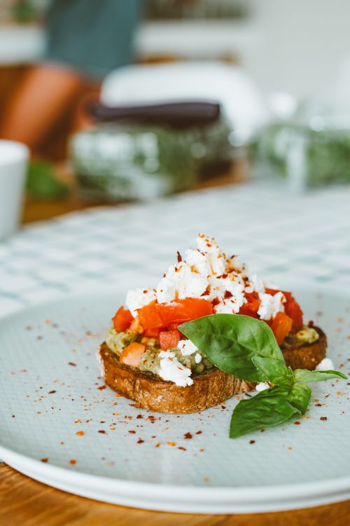 Free Close-up of a savory bruschetta with feta, tomatoes, and fresh basil. Stock Photo