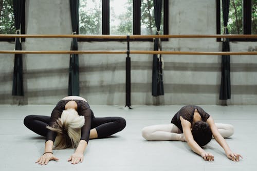 Flexible ballerinas working out in studio with barre