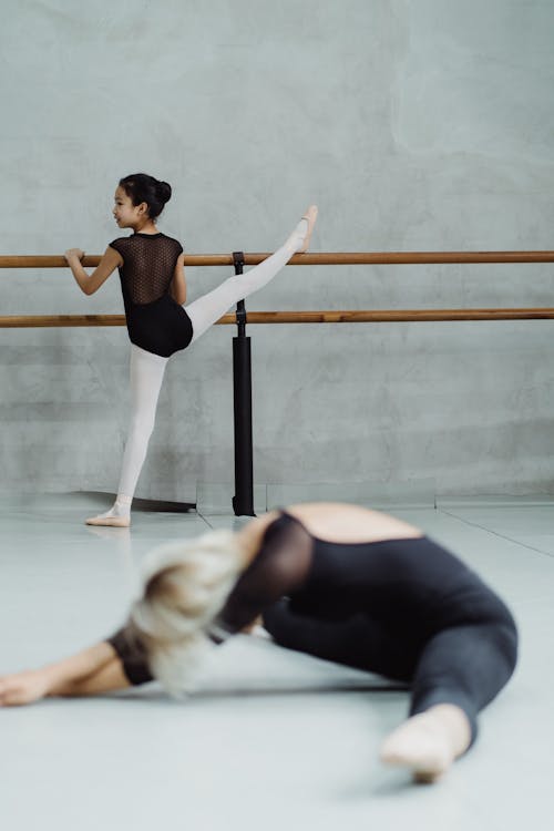Ballerina girls stretching legs in studio