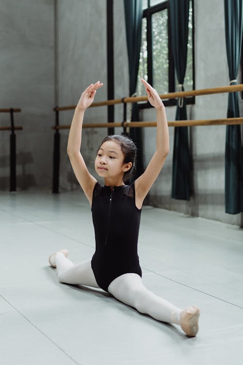 Konzentrierte Ethnische Tänzerin, Die Im Ballettstudio Die Beine Streckt