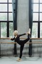 Woman practicing arabesque with barre in studio