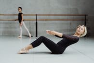 舞蹈课上，亚洲芭蕾舞教练与女孩排练的全身侧面图