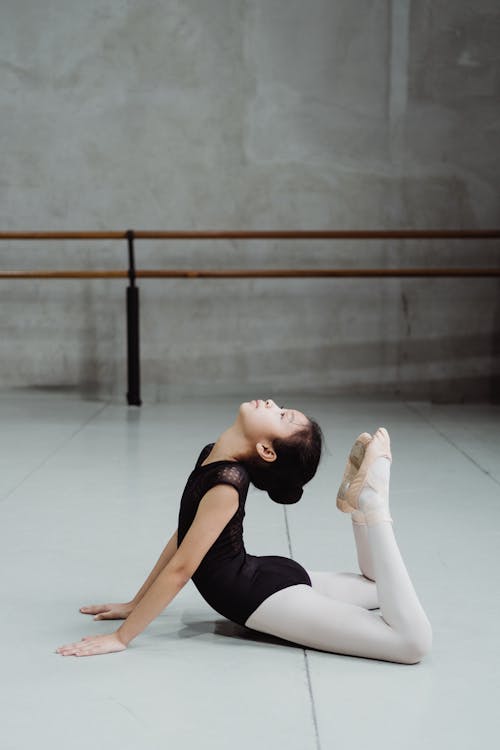 Free Asian girl stretching body on floor in studio Stock Photo