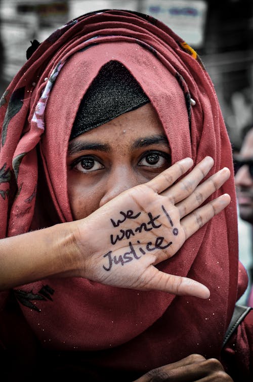 Woman in Hijab with We Want Justice Text on Hand