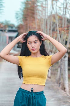 Portrait of a young woman posing confidently in casual attire outdoors.