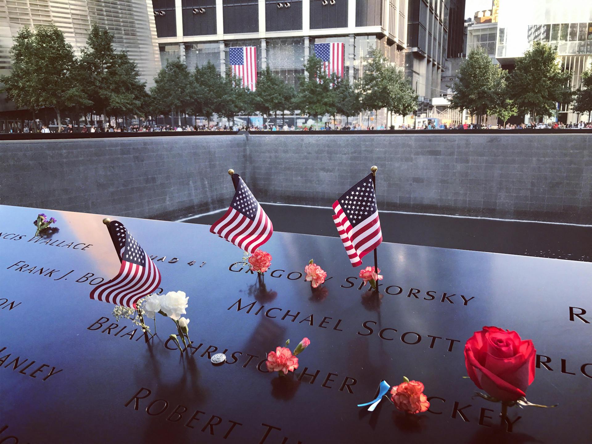 Flags of USA and Flowers on Names on 9/11 Memorial in New York