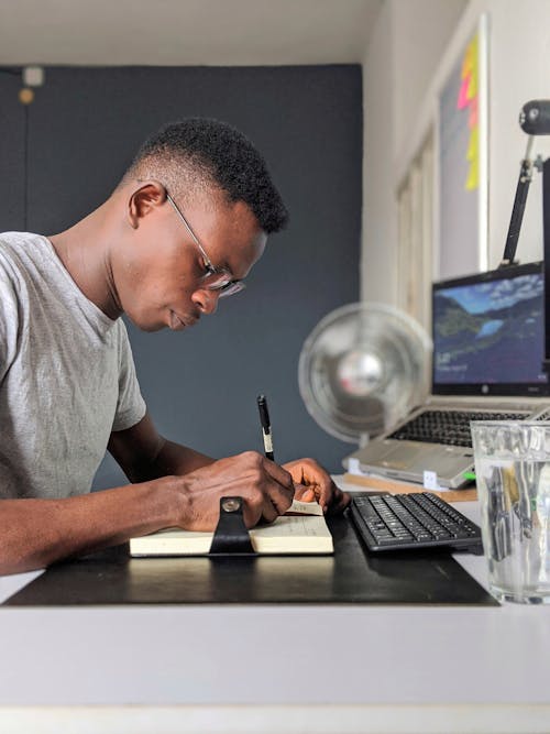 Man Taking Notes at Desk