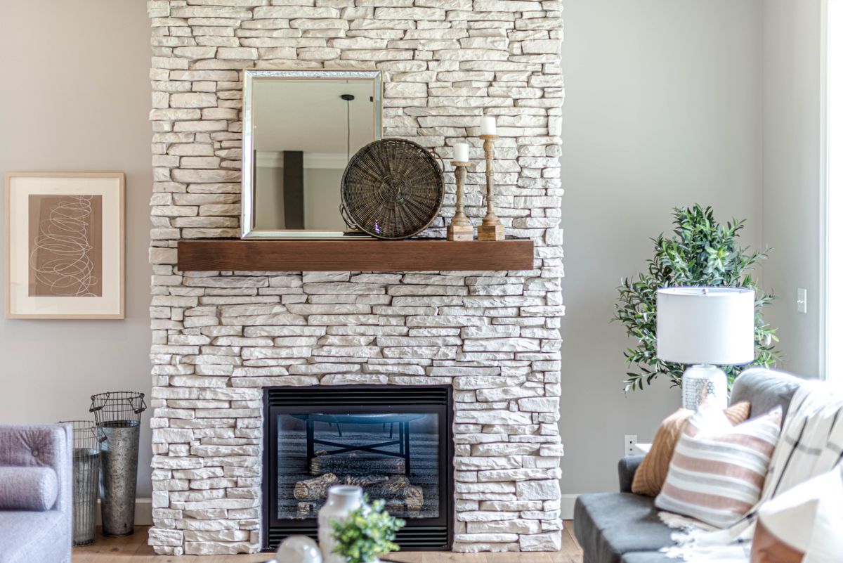 Cozy living room featuring a stylish stone fireplace and elegant decor pieces. Stock Photo.
