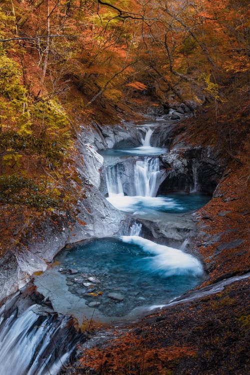 Turquoise cascade in autumn forest
