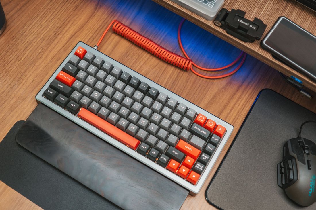 Grey and orange mechanical keyboard with a coiled cable