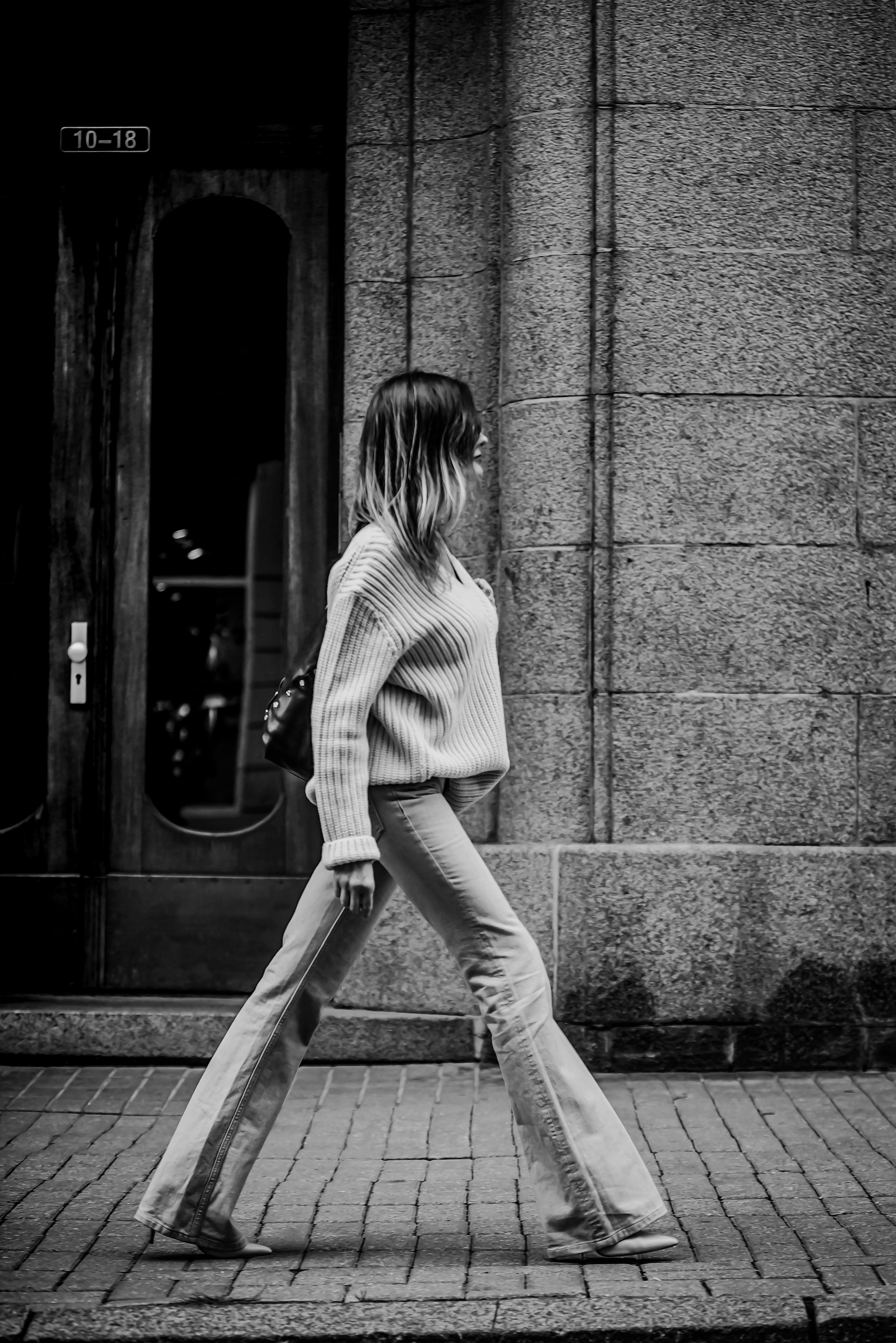 A Grayscale Photo of a Woman Walking · Free Stock Photo