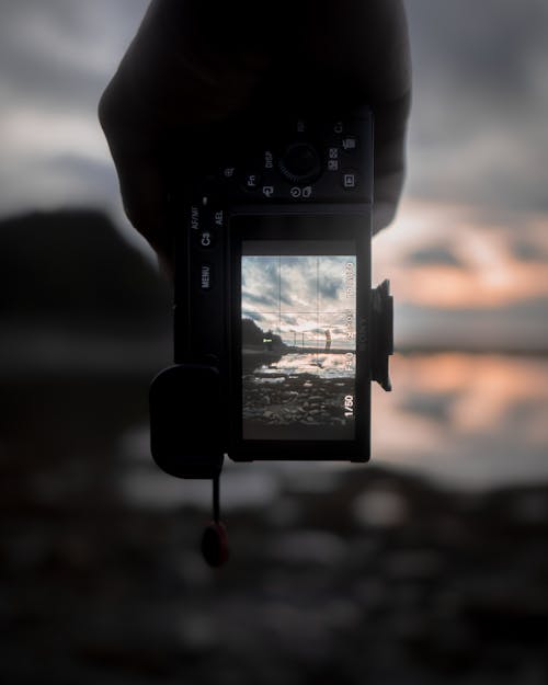 Free Unrecognizable person taking photo of sea at sunset Stock Photo