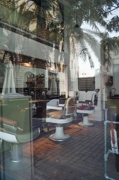 Stylish barber shop interior with classic chairs and natural reflections through the window.