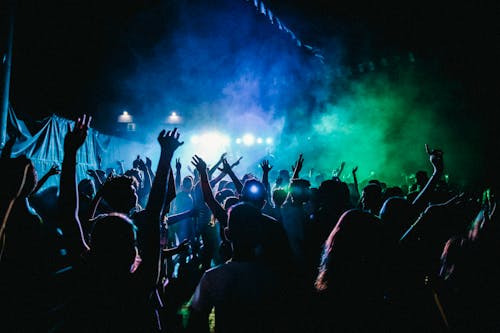 Free People Raising Their Hands in Front of Stage With Lights Stock Photo