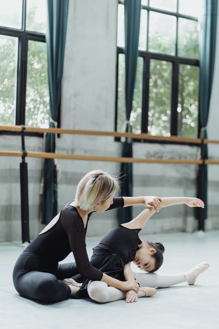 Anonymous Instructor Helping Asian Pupil To Stretch During Ballet Workout