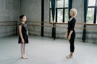 Ballerina instructor and girl trainee standing in studio