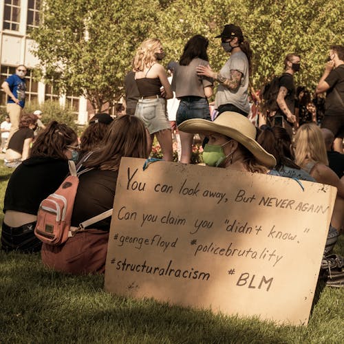 Free Group of friends protesting against racial discrimination in park with placard Stock Photo