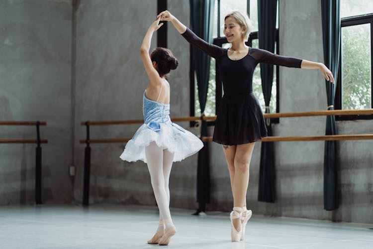 Asian Ballerinas Performing Ballet Dance In Studio