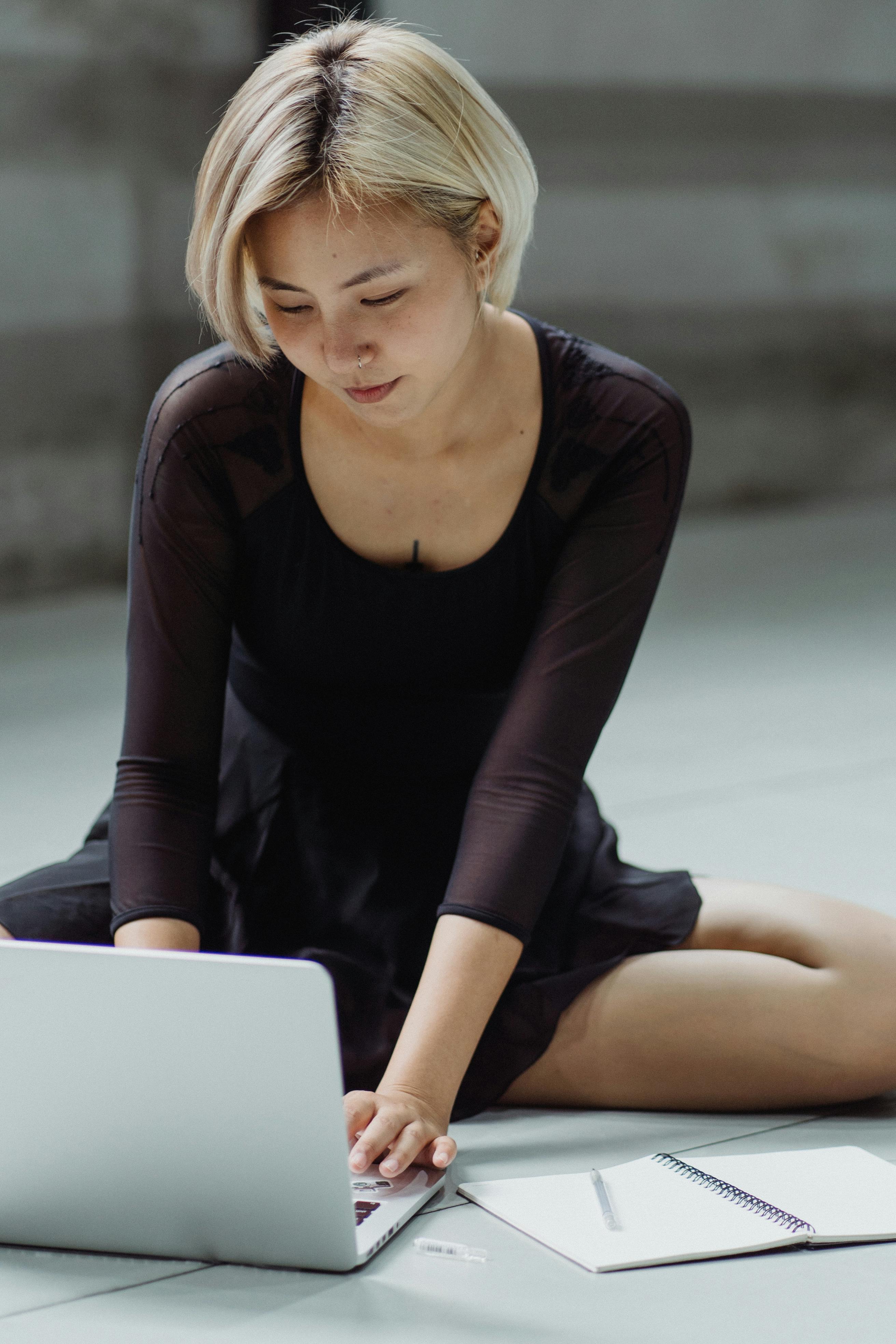asian woman using laptop on floor