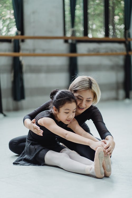 Asian female ballet instructor helping ballerina girl to stretch body · Free  Stock Photo