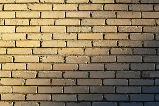 Detailed close-up of a sunlit brick wall showcasing texture and pattern in warm tones.