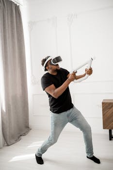 A man enjoying a virtual reality experience with VR glasses and a controller indoors.