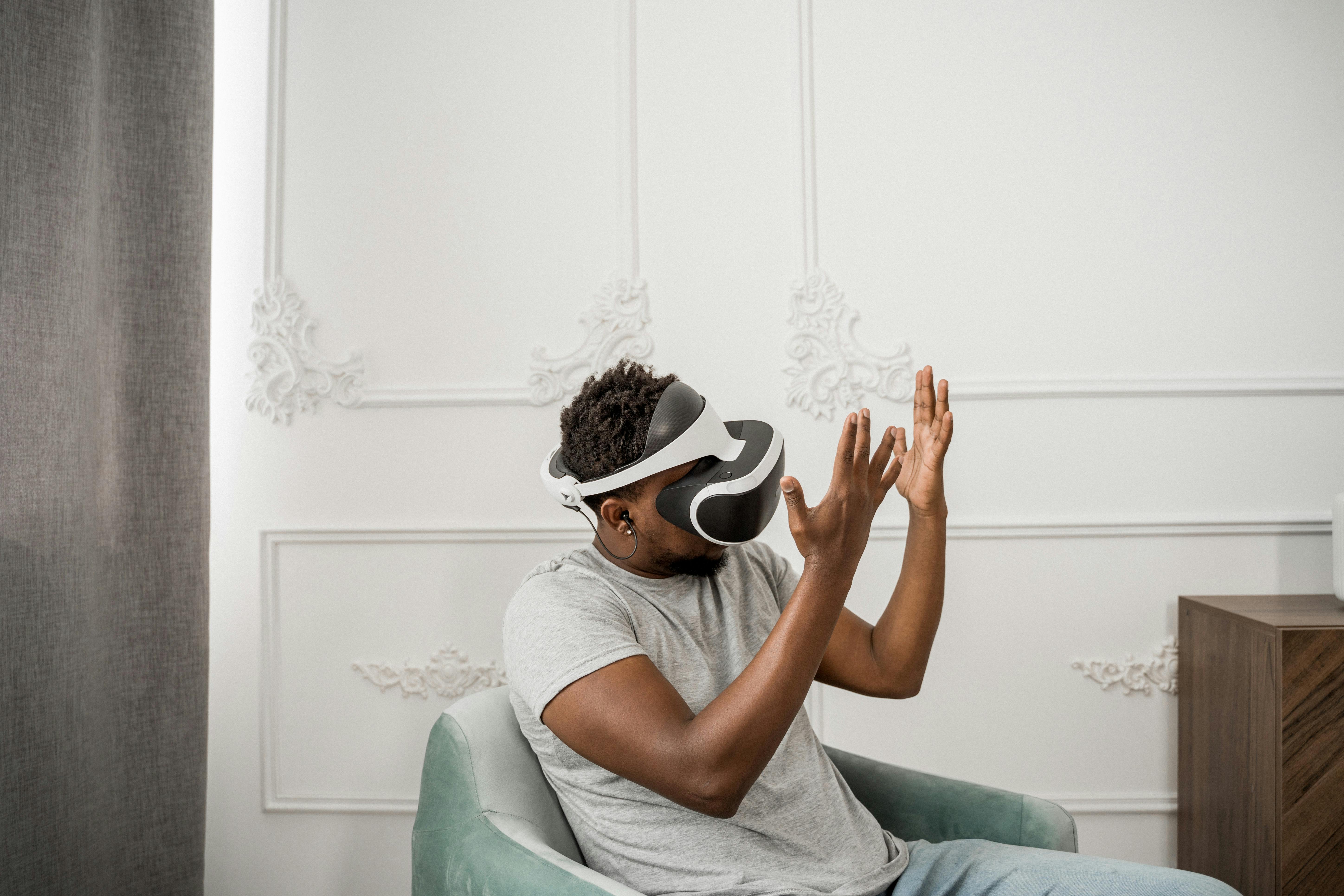 man in gray crew neck t-shirt wearing white and black VR goggles
