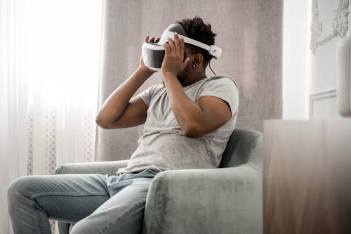 Free Man in Gray Crew Neck T-shirt Wearing White and Black Vr Goggles Stock Photo