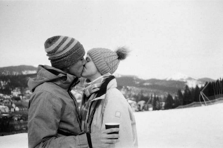 Couple Kissing Outdoors In Mountains In Winter 