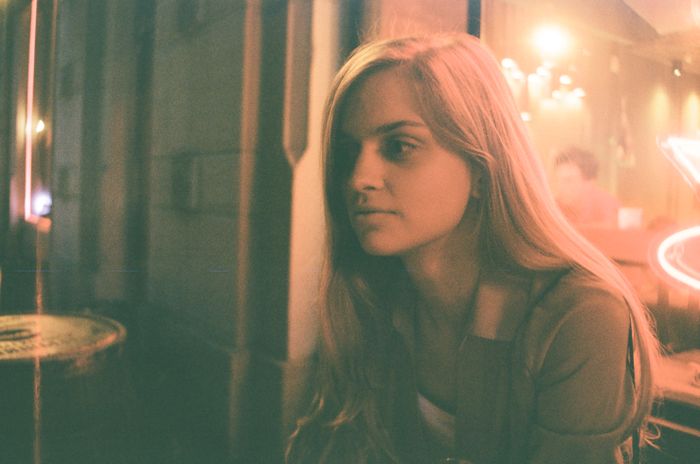 Della Roan, portrait in warm bar light — photograph by Polina Hedzenko on Pexels
