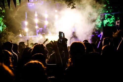 Free Dynamic crowd enjoying a lively outdoor concert with colorful lights and vibrant atmosphere. Stock Photo