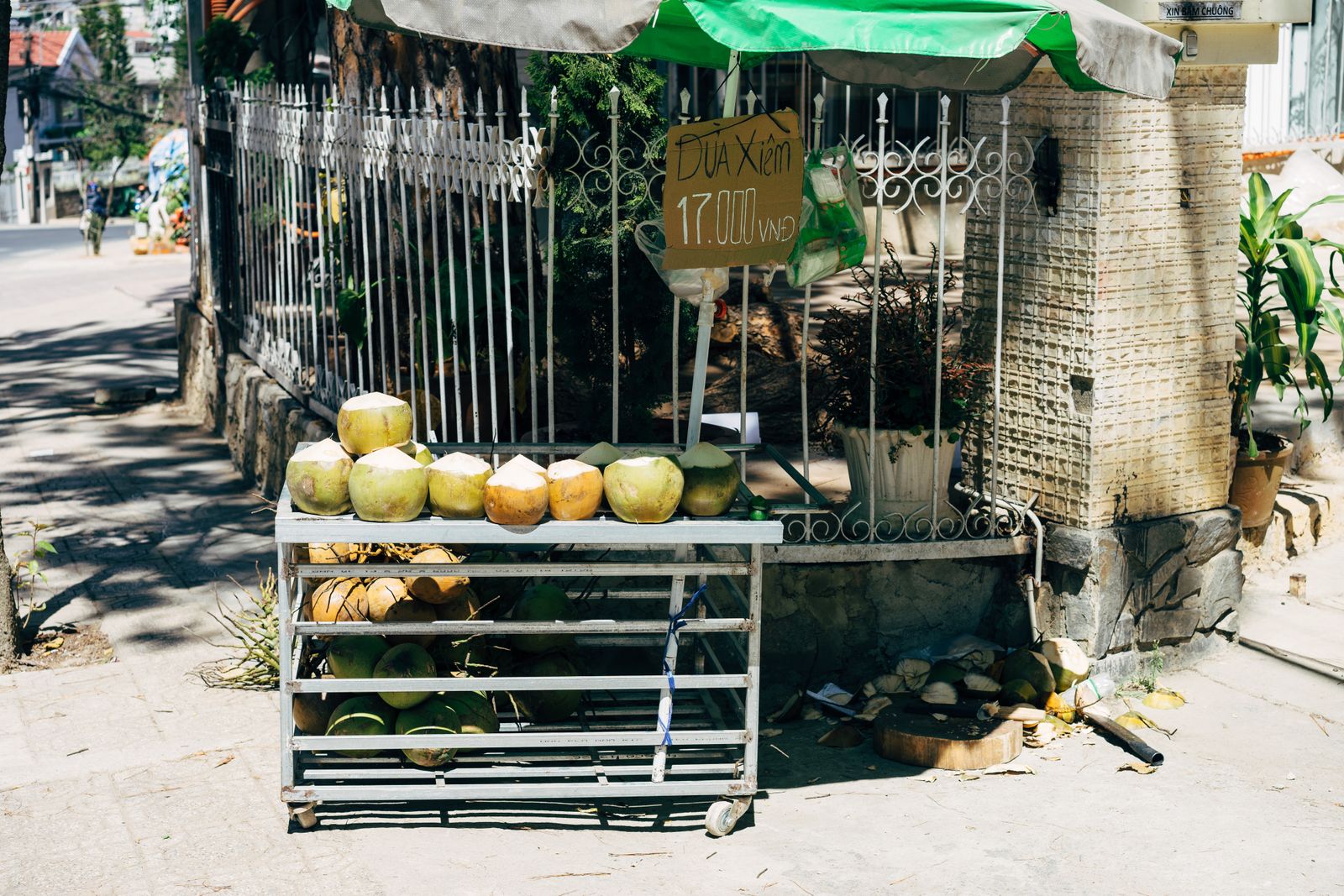 Street-side coconut stall selling fresh coconuts in Vietnam.