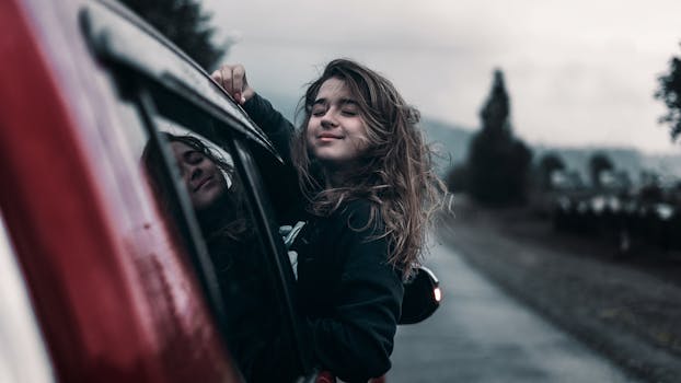 A cheerful woman enjoys the freedom and serenity of a road trip through the countryside.