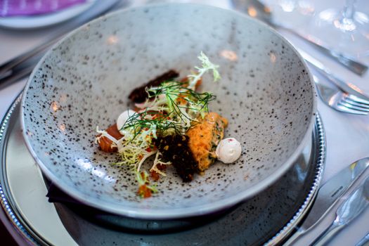 Close-up of a gourmet meal served on a stylish plate, featuring fresh herbs and delicate presentation.
