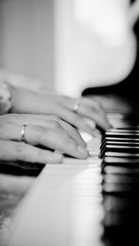 A close-up of hands playing piano keys, focusing on musical expression and detail.