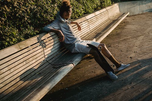 Patineur Masculin Reposant Sur Un Banc Minable Dans Le Parc