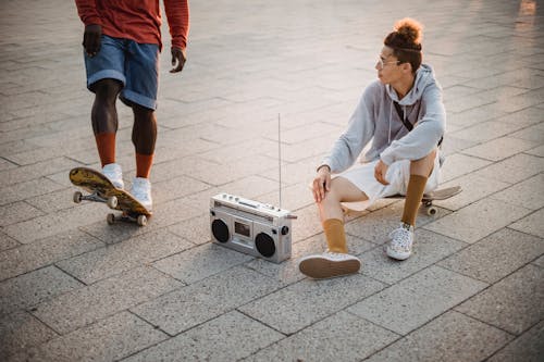 Diverse male skaters listening to music via boombox