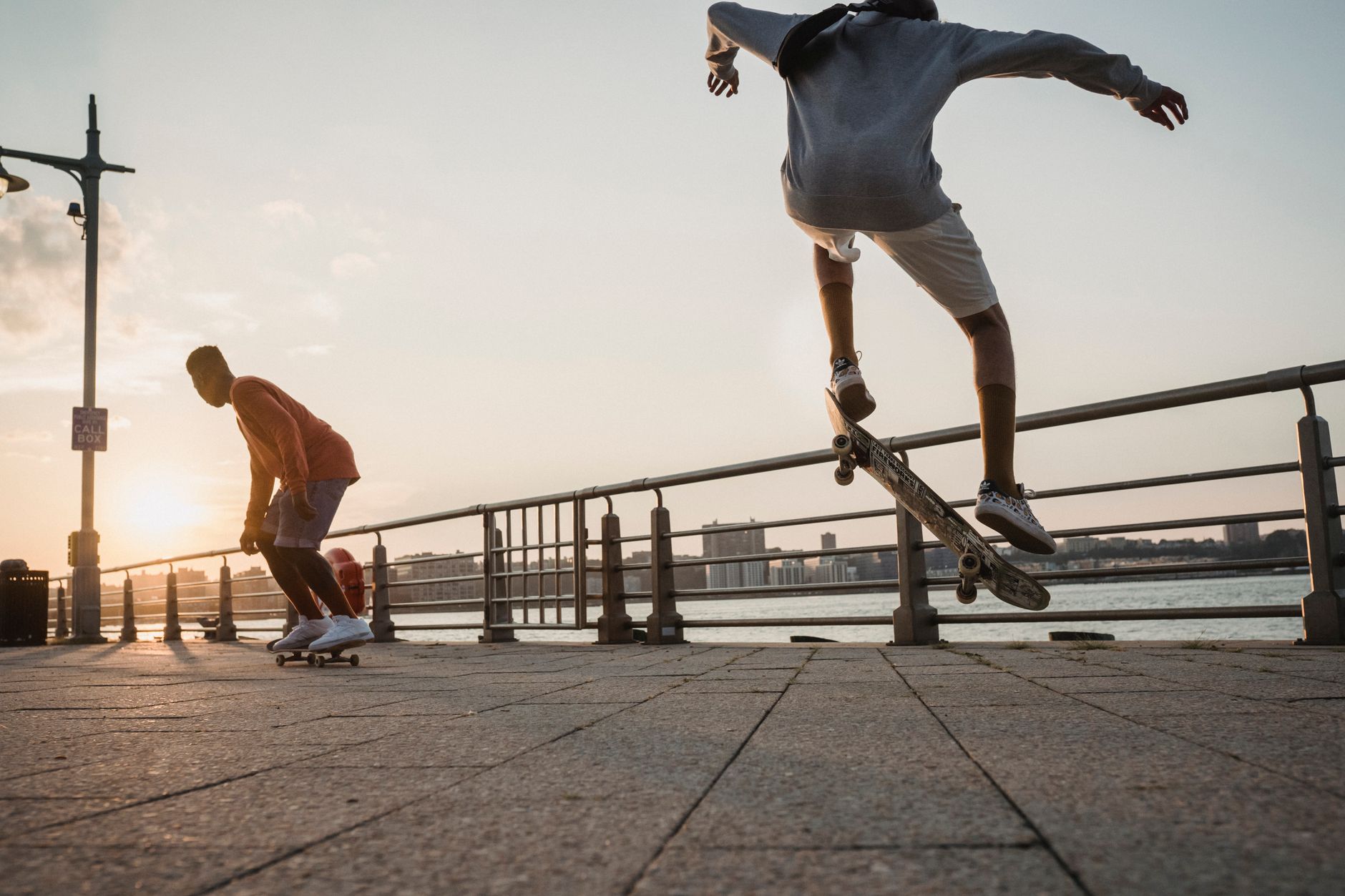 Houston street skaters practicing pool lines near sunlit concrete bowls, with punk posters on a nearby wall