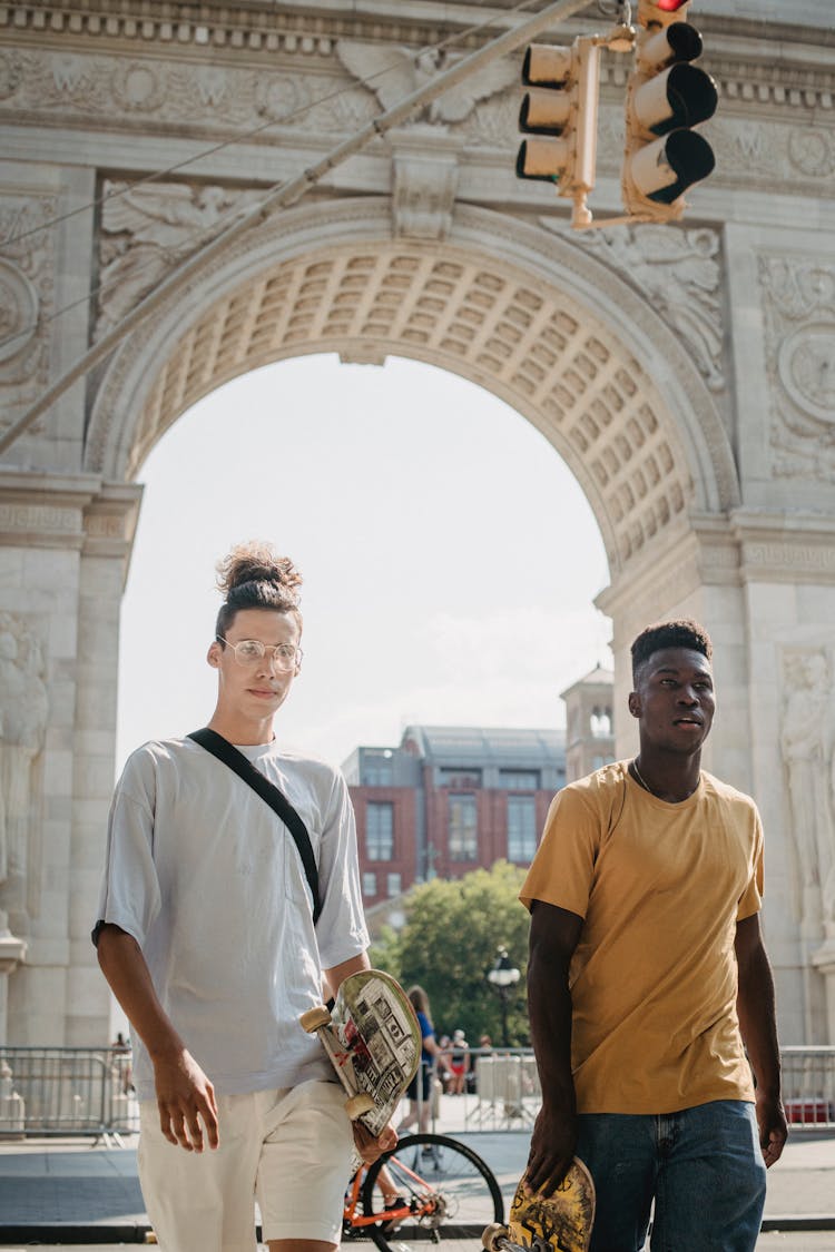 Diverse Friends With Skateboards On City Street