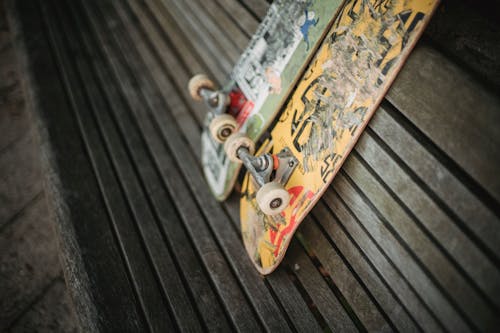 Shabby skateboards on wooden bench in park