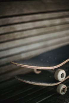 Close-up view of skateboards stacked on a wooden bench, capturing the essence of street sport culture.