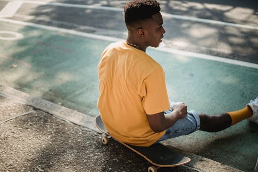 A relaxed young man in yellow on a skateboard in a sunny urban setting.