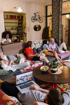 A diverse group of friends enjoying a cozy and casual hangout in a decorated living room.
