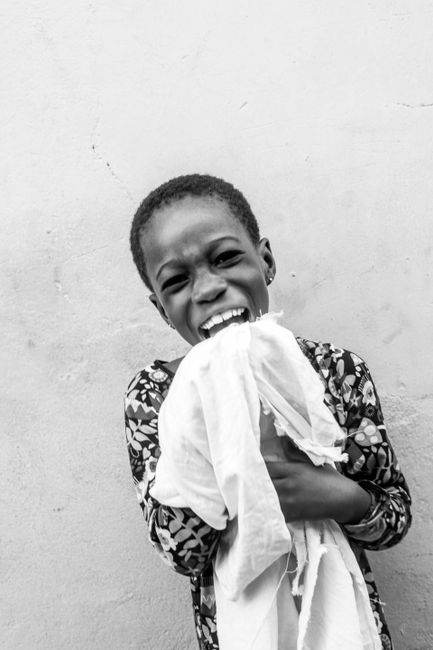 A black and white portrait capturing a child's pure happiness and laughter.