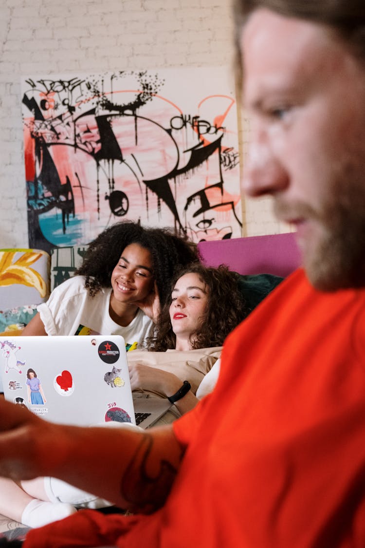 Women Sitting On The Couch Looking At A Laptop Computer