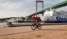 Man in Red Jacket Riding Bicycle on Bridge