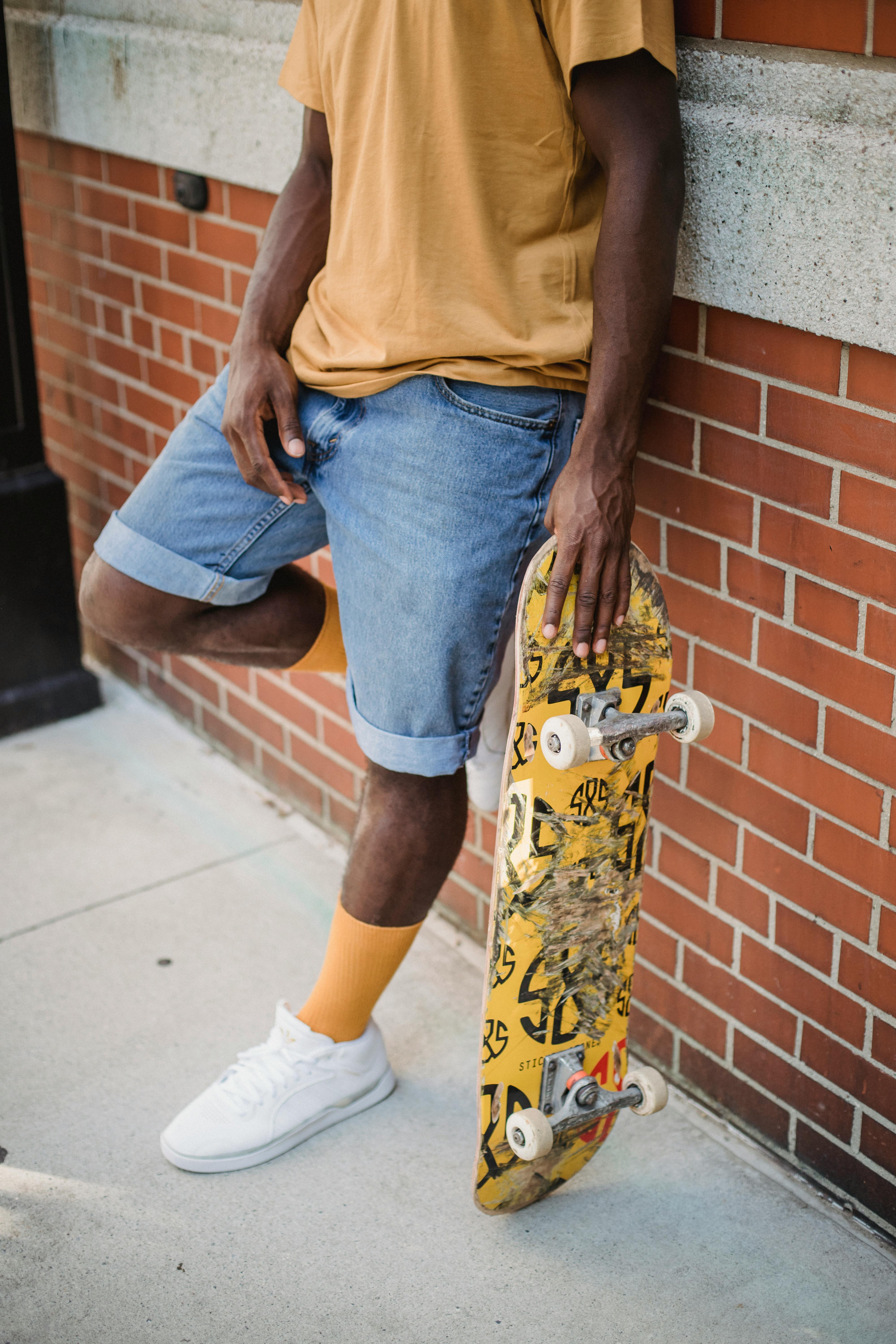 男子站在砖头上，踩着滑板，拥抱城市街头风格