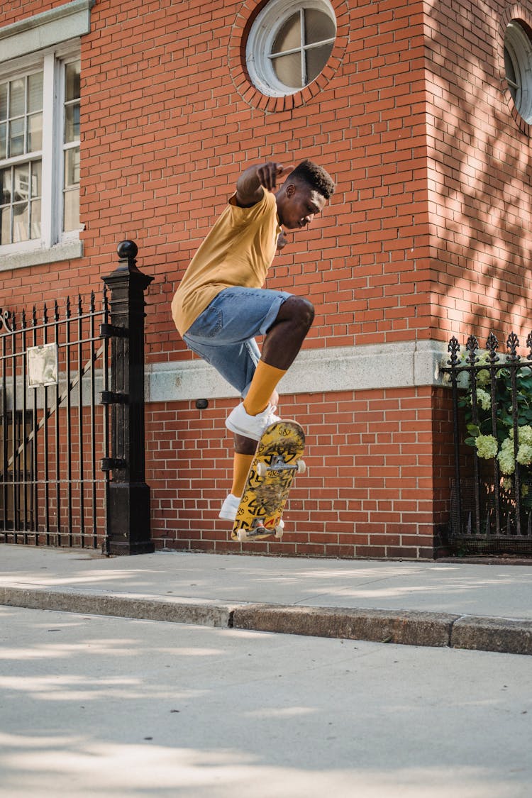 Sporty Black Skater Performing Tricks On Skateboard