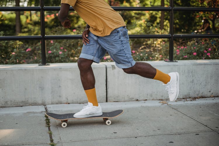 African American Skater Riding Skateboard On Street In Daytime